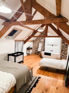 a bedroom with two beds and a stone wall at La Maison Gavraise in Gavray