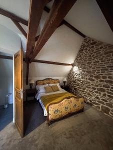 a bedroom with a bed in a stone wall at La Maison Gavraise in Gavray