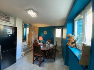 une salle à manger avec une table et des murs bleus dans l'établissement Au Lavoir, à Vinzelles
