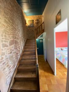 un escalier dans une pièce dotée d'un mur en briques dans l'établissement Au Lavoir, à Vinzelles