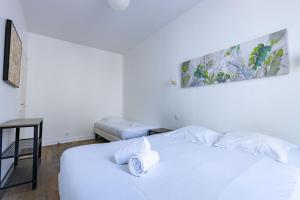 um quarto branco com uma cama branca e um banco em Le Grand Bilobou em Noyers-sur-Cher