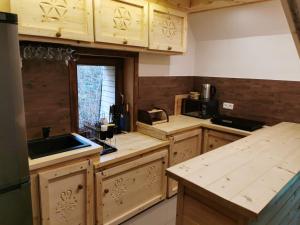 una cocina con armarios de madera y fregadero en Dacza Zakątek en Falsztyn