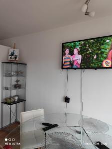 a living room with a table and a tv on the wall at Wohnung mit Weitblick in Schwäbisch Hall