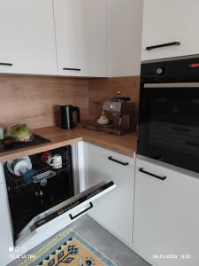 a kitchen with white cabinets and a black oven at Wohnung mit Weitblick in Schwäbisch Hall