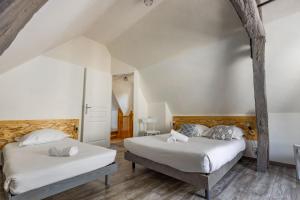 Duas camas num quarto com paredes brancas e pisos em madeira em Faune em Saint-Aignan