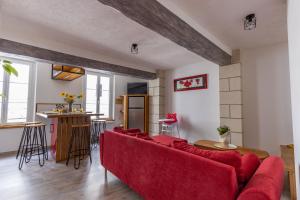uma sala de estar com um sofá vermelho e uma mesa em Faune em Saint-Aignan