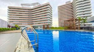 a large swimming pool with two tall buildings at Nuvasa Bay The Nove Kalani Tower in Telukmataikan