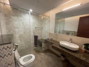 a bathroom with a toilet and a sink and a mirror at AirReside Hotel Apartments Gold Crest in Lahore