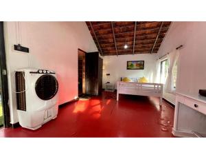 Habitación con 1 cama y ventilador. en The Earthen Nest Resort, Canacona, Goa en Poinguinim