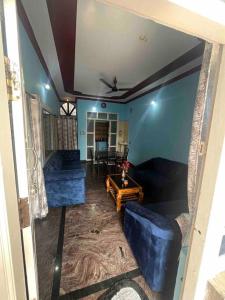 - un salon avec deux canapés bleus et une table dans l'établissement Dreamy bungalow 2BHK apartment, à Mysore