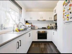 Cucina o angolo cottura di BIDWILL GARDENS ON MIDDLETON - Private Room King-Size Bed or Open Lounge Room Floor Mattress SHARED Bathroom FREE Kitchen Essentials FREE Laundry Facilities Fast NBN WIFI HDTV NETFLIX, YOUTUBE, KAYO Private Transport and Meal Services Available On Request