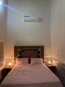 um quarto com uma cama grande com duas velas nas mesas em Riad Ranya em Fez mais 68 fotografias