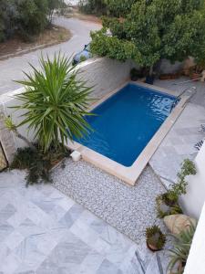 una piscina en medio de un jardín en Villa des plaisirs, en Borj el Khessous