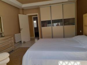 una camera con un grande letto bianco e un comò di Villa des plaisirs a Borj el Khessous