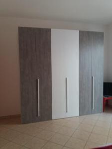 2 armarios de madera en una habitación con suelo de baldosa en villa lucia, en Mondragone