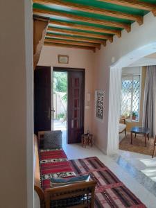 sala de estar con cama y habitación con puerta en Villa des plaisirs, en Borj el Khessous