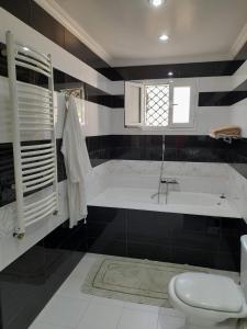 y baño con bañera, aseo y lavamanos. en Villa des plaisirs en Borj el Khessous