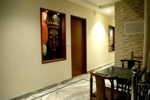a room with a table and a painting on a wall at Pyrenees Homestay in Agra