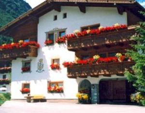 a white building with flower boxes on it at Garni Ferwall in Galtür