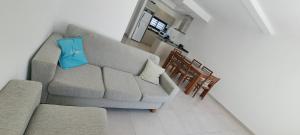 a living room with a couch and a blue pillow at Berasain Apartment - Tu hogar cerca del Aeropuerto de Ezeiza in Monte Grande