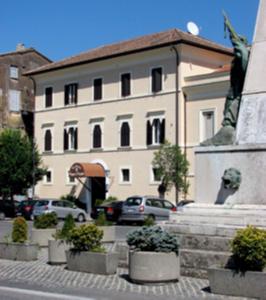 Una statua di un uomo davanti a un edificio di Residenza Principe Di Piemonte a Ronciglione