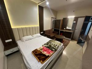 a small bedroom with a bed and a chair at Hotel Punjab in Rourkela