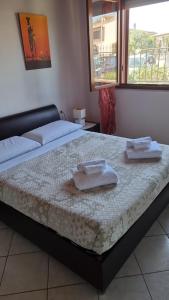 a bedroom with a bed with two towels on it at Casa Azzurra in San Sperate