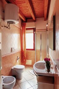 y baño con aseo y lavamanos. en Casa Azzurra, en San Sperate