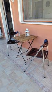 una mesa y dos sillas sentadas junto a una pared en Casa Azzurra, en San Sperate