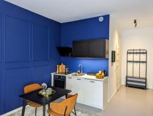 una cucina con pareti blu e tavolo e sedie di Bella Luna Luxury Suites - Chic Residence in Historic Square a Varsavia