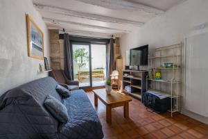 a living room with a couch and a tv at Les marmousets, 5 minutes du Zoo in Saint-Aignan