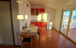 una cucina con tavolo e sedie e una cucina con tavolo e tavolo di Apartments Maruna a Maslenica