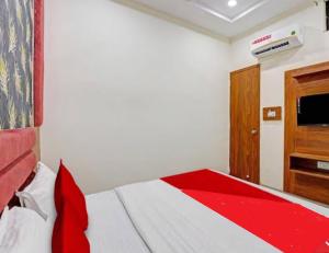 a bedroom with a bed and a tv on the wall at Hotel Rudrax - Anand in Anand
