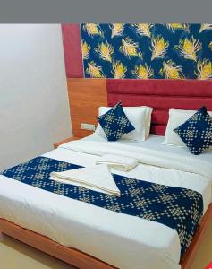 a hotel room with a bed with blue and yellow patterns at Hotel Rudrax - Anand in Anand