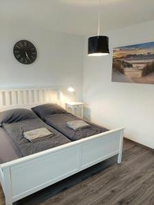 1 dormitorio con 1 cama con reloj en la pared en Lech Appartement, en Landsberg am Lech