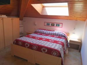 1 dormitorio con 1 cama con edredón rojo en Maso Sveseri, en Montesover