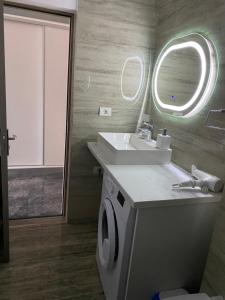 a bathroom with a sink and a washing machine at Serin Blaxy Studio in Mangalia