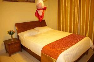 a bedroom with a bed with a red ribbon hanging above it at QUINTEN HOTEL KISUMU in Kisumu