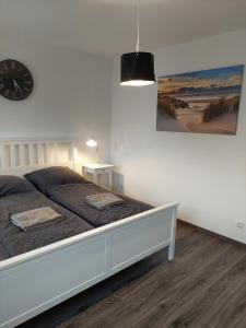 Un dormitorio con una cama con un reloj en la pared. en Lech Appartement, en Landsberg am Lech