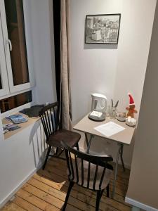 eine kleine Küche mit einem Tisch und 2 Stühlen in der Unterkunft La chambre de pousse in Boulogne-sur-Mer