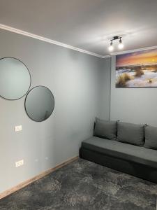 a room with a couch and two mirrors on the wall at Serin Blaxy Studio in Mangalia