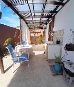 un patio con mesa, sillas y toldo en Suite Privativa Lar e Aconhego, en Maricá