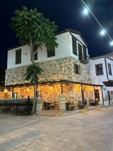 a large stone building with a tree in front of it at Scala Otel in Cesme
