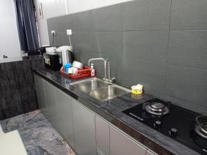 a kitchen with a sink and a counter top at RizqFateh Homestay in Kluang