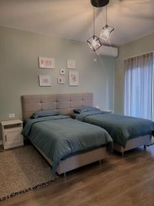 a bedroom with two beds and a window at Central Gem Tirana in Tirana