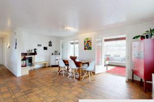 a kitchen and living room with a table and chairs at Cheerful villa with fireplace, bath-tub and garden in Noville +21 photos