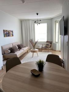 een woonkamer met een tafel en een bank bij Beautiful apartment - own parking space included in Vantaa