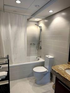 a bathroom with a toilet and a bath tub at City center with Burj View! in Dubai