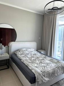 a bedroom with a bed and a window at City center with Burj View! in Dubai