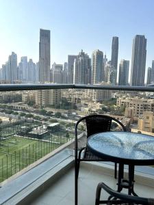 a table and chairs on a balcony with a view of a city at City center with Burj View! in Dubai